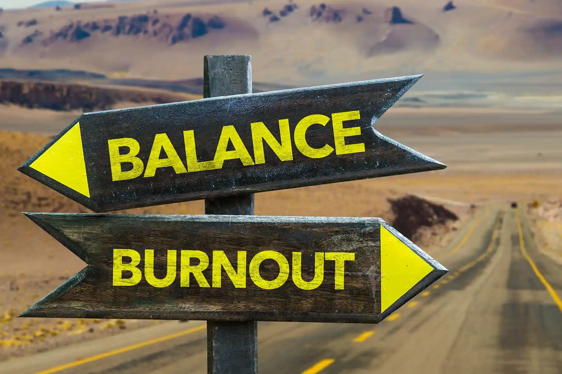 Picture of two signs that say burnout and balance, facing different sides