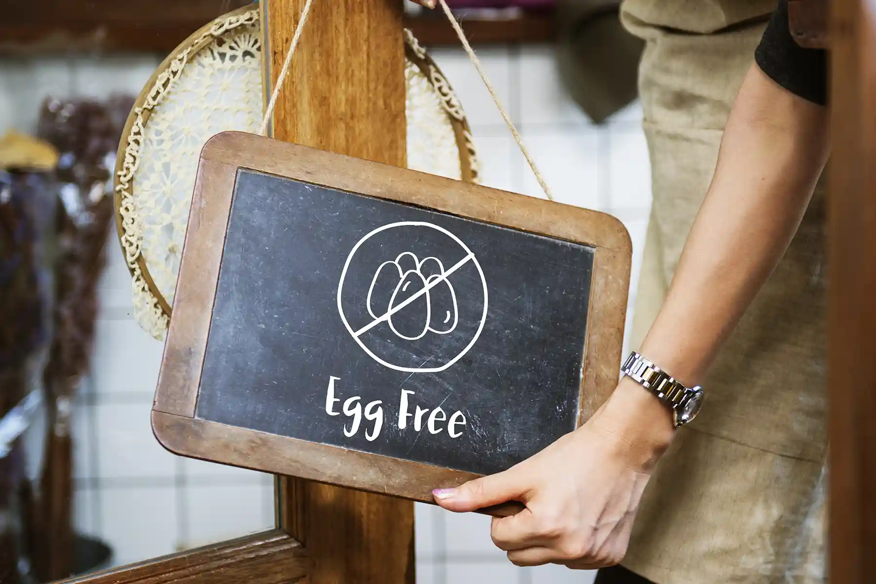 A man placing an egg free signage