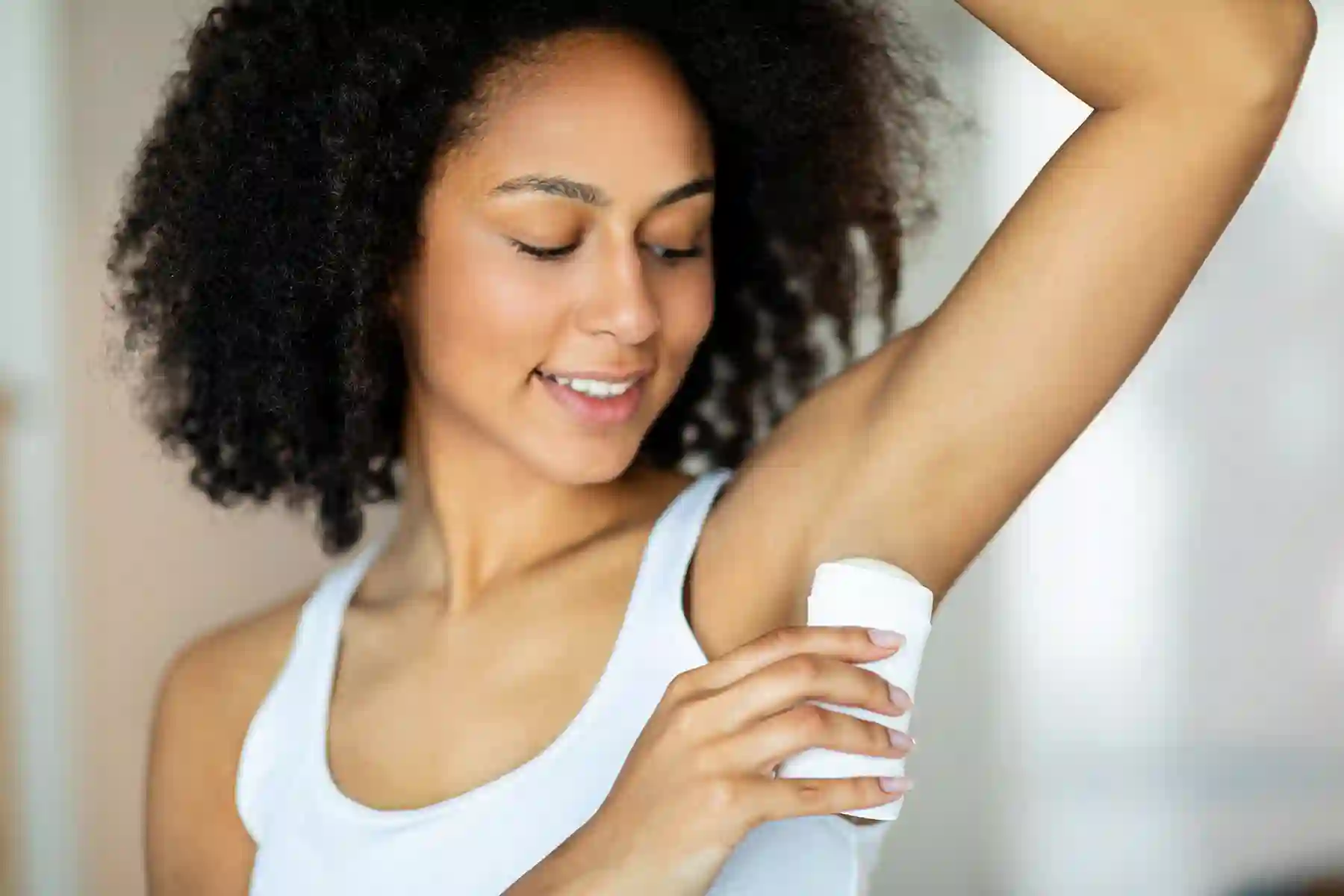 a woman applying deodorant