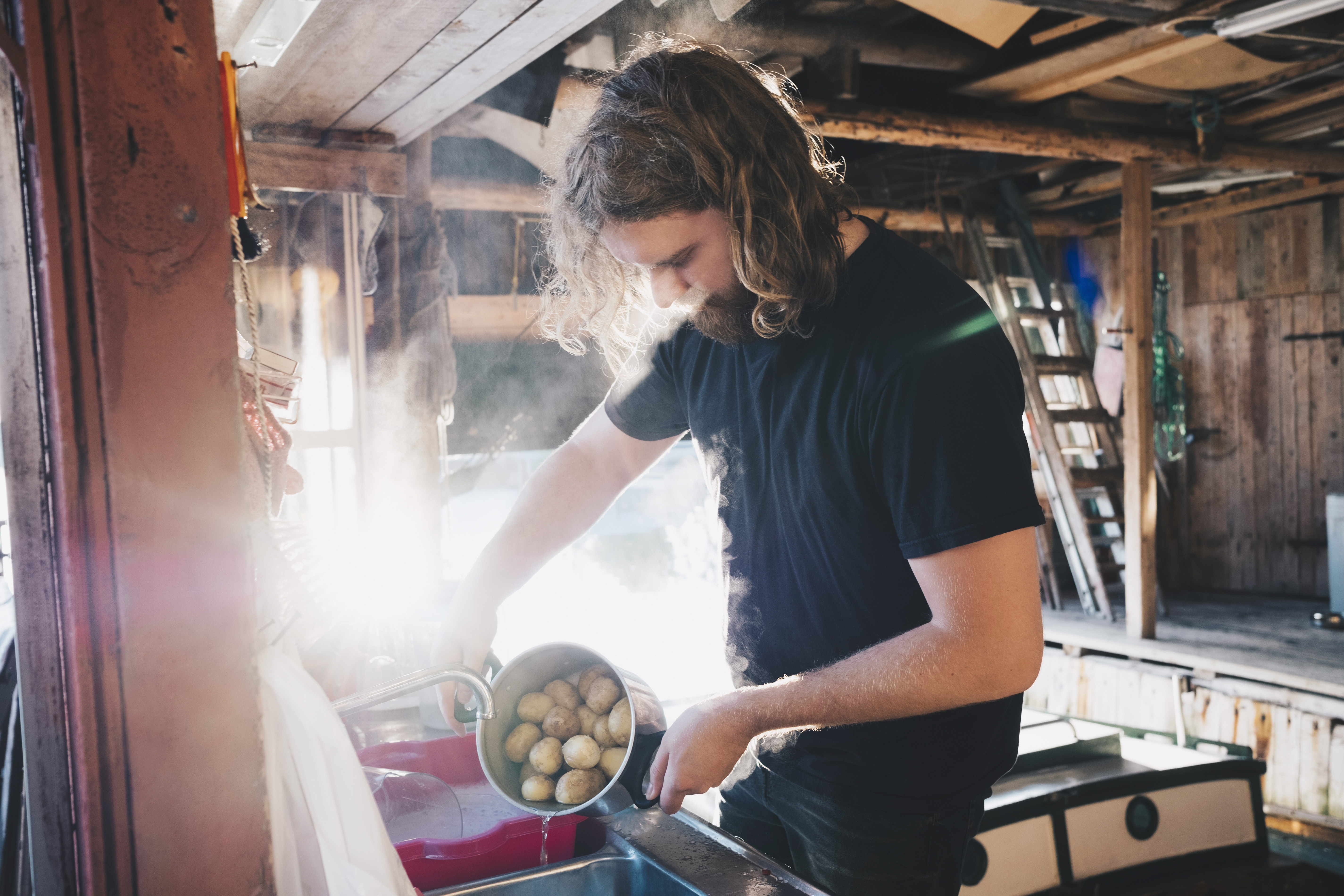 Mann bruker strøm på hytta når han koker poteter