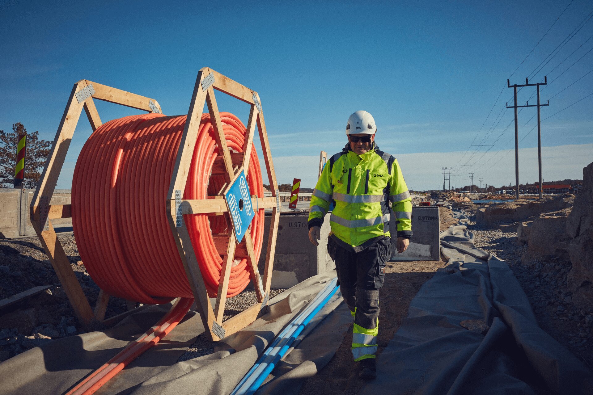 Mann og en trommel med kabel. Foto