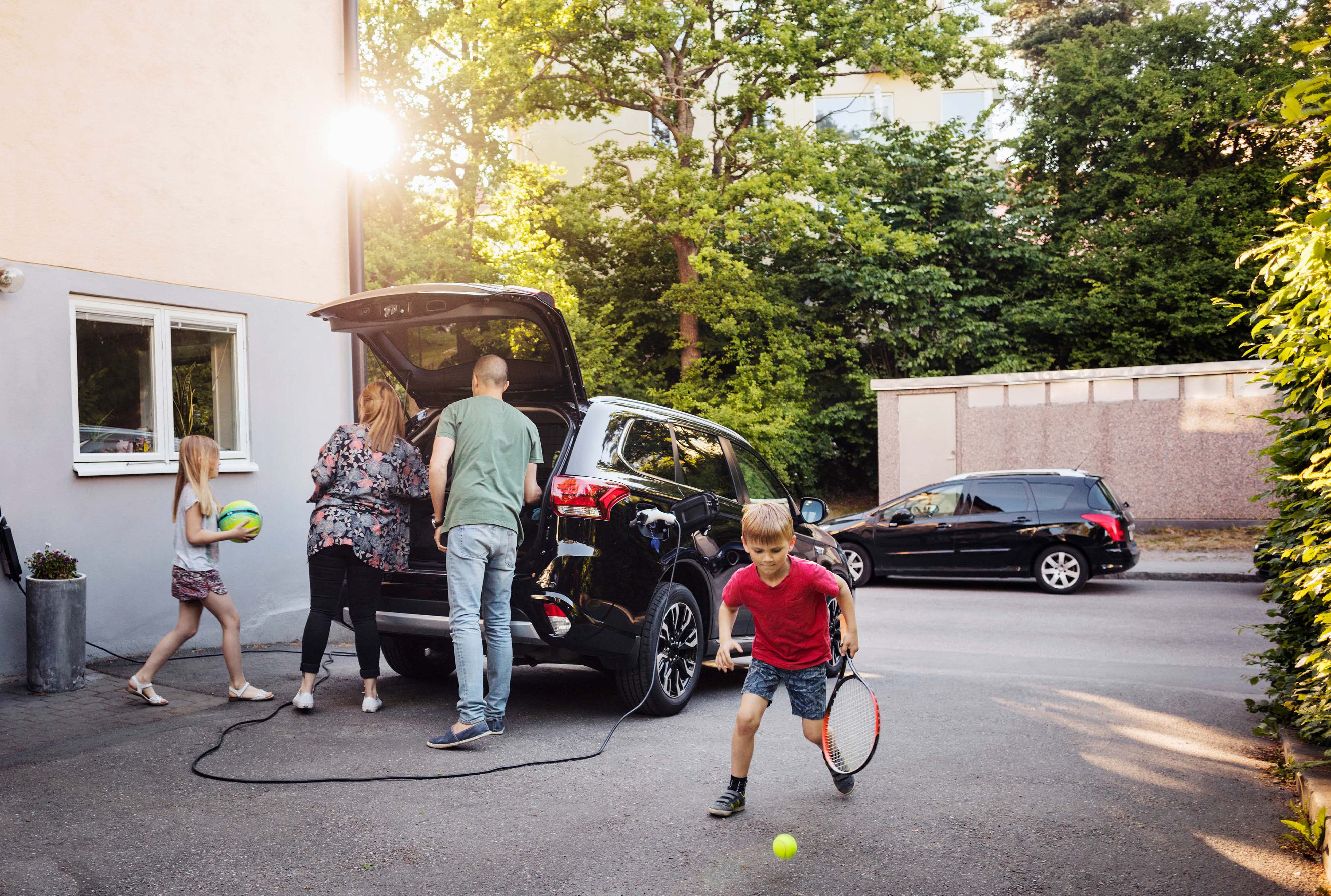 Familie som pakker elbilen klar for elbilferie