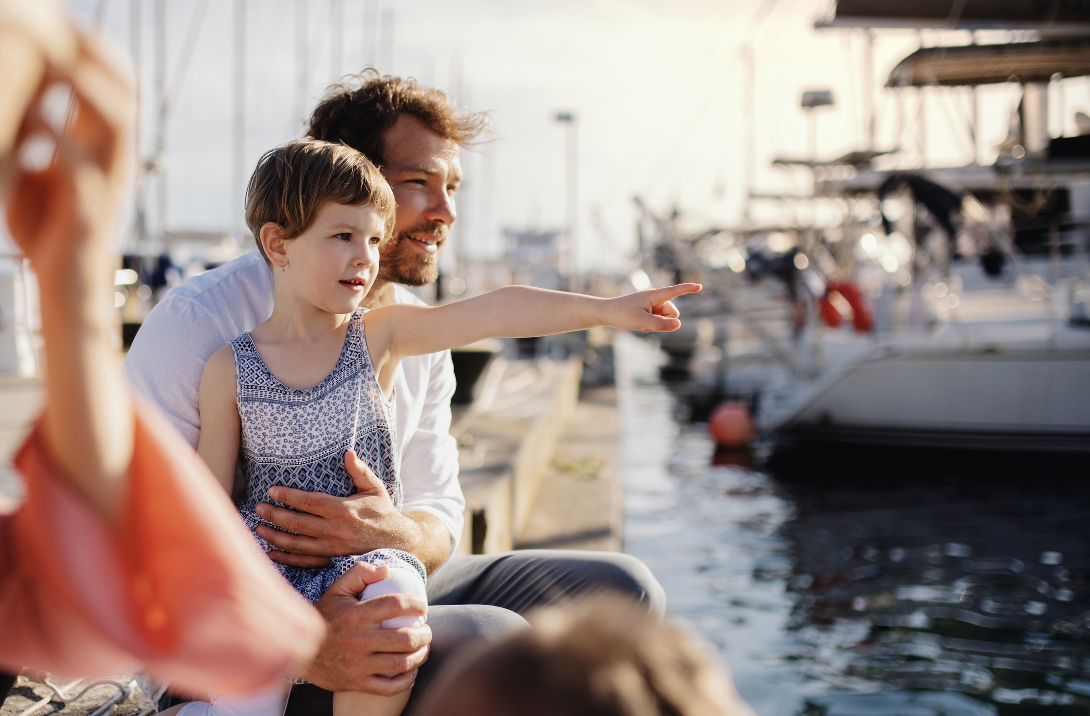 Far og datter ser på båtene i havnen 