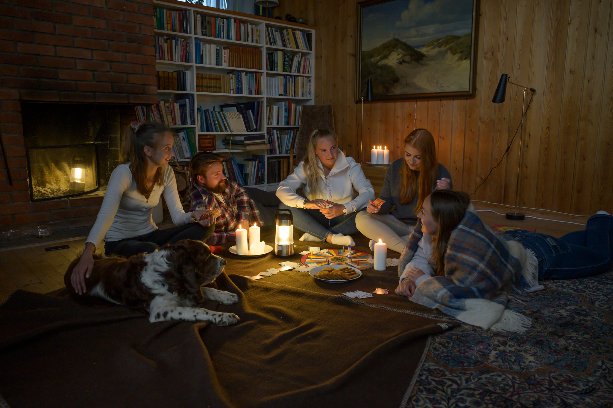 Familie sitter på gulvet med levende lys. Foto