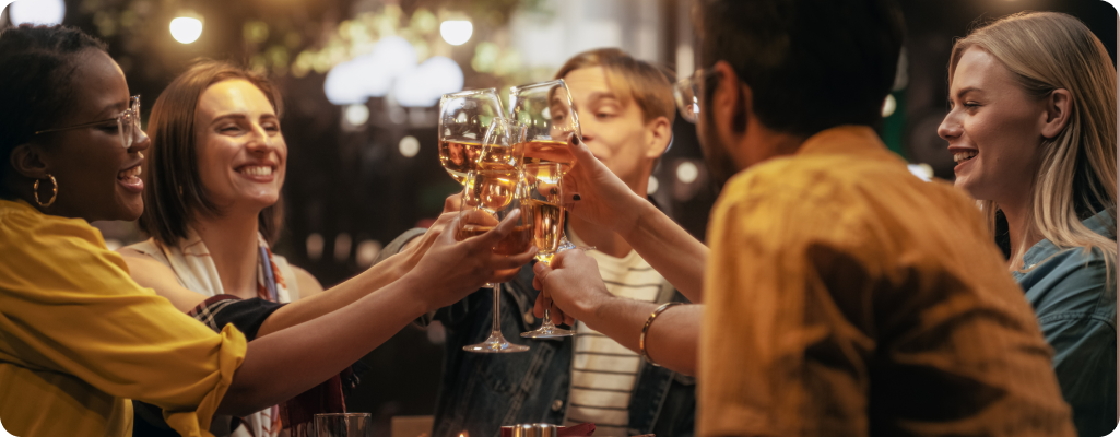 image of a group of people clinking white wine glasses