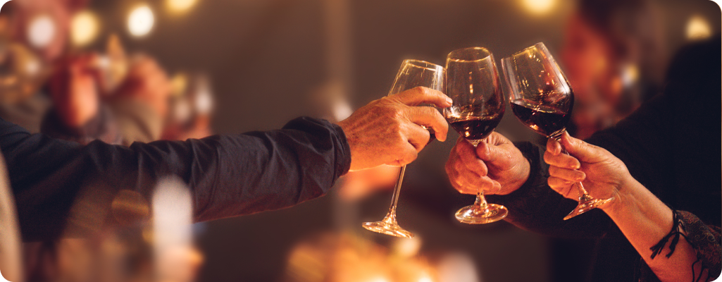 image of three people clinking full glasses of red wine