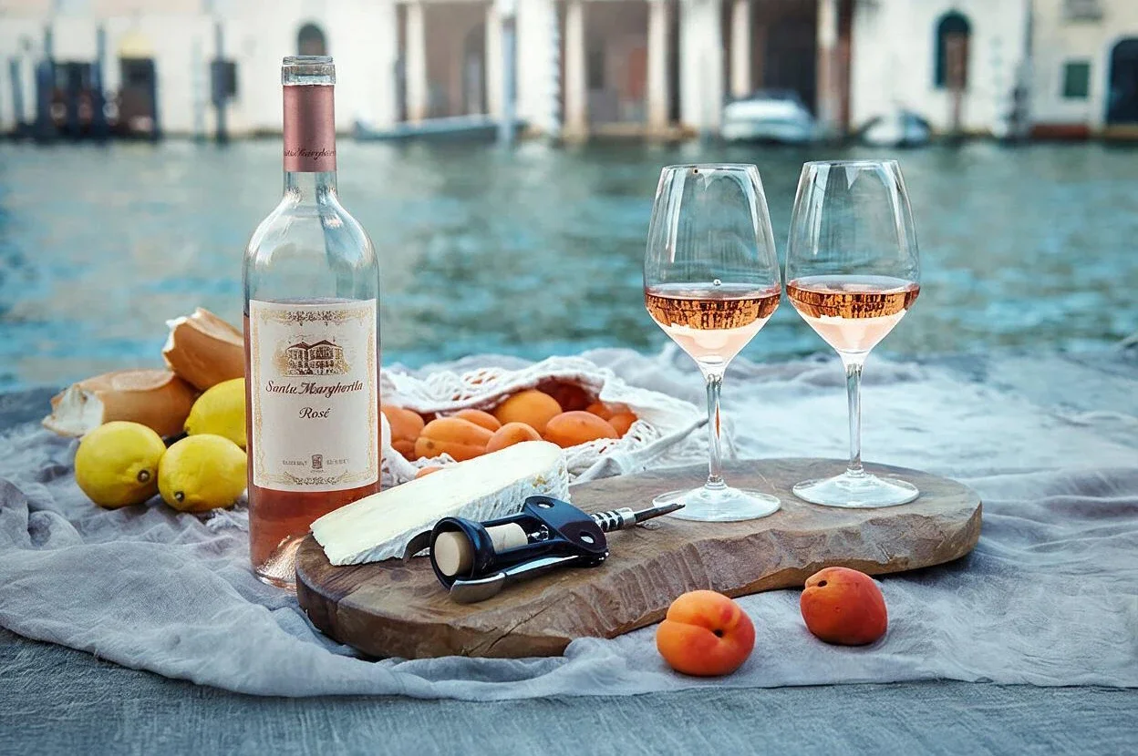 Rosé wine with fruit and snacks on a wooden pier
