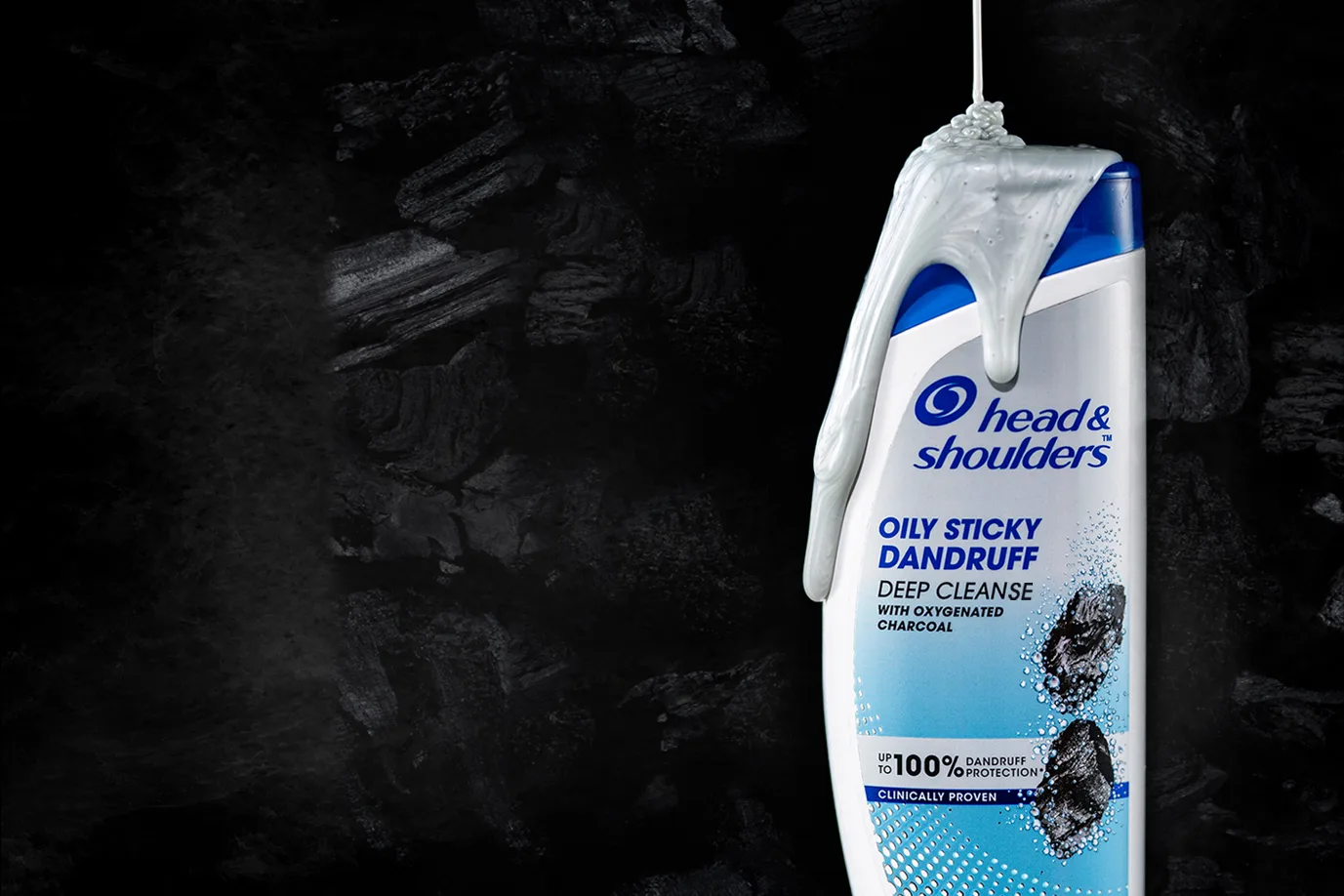 Image of a bowl filled with fine activated charcoal powder placed along with a bottle of Head & Shoulders Deep Cleanse Charcoal Shampoo