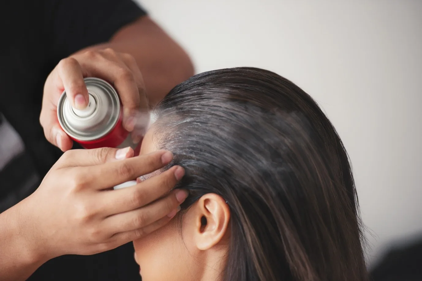 Woman applying hair spray
