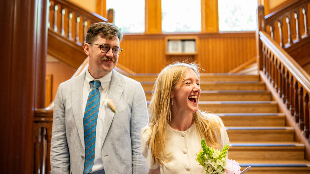 Bride and groom laughing on stairs