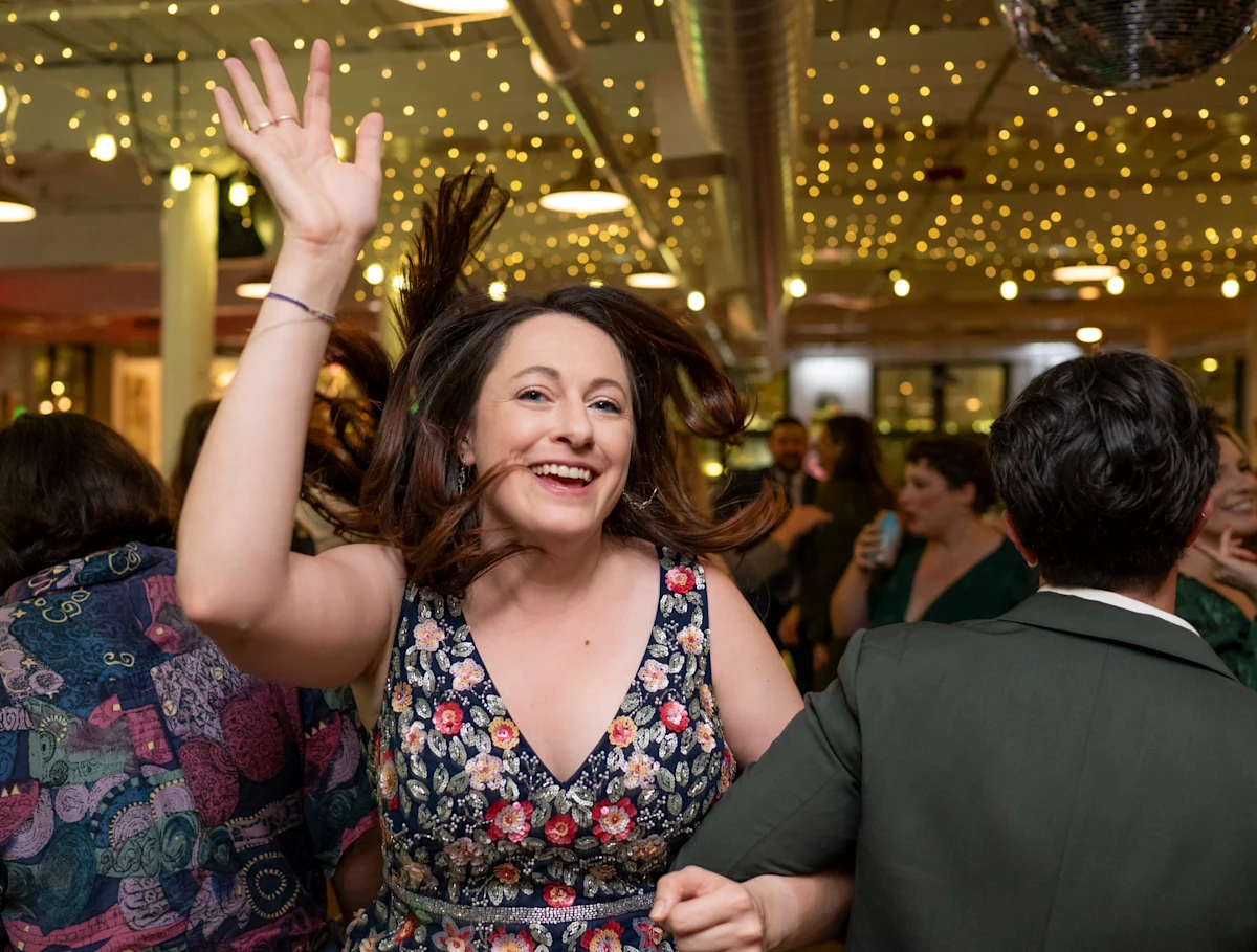 Woman on dance floor spinning while locking arms.