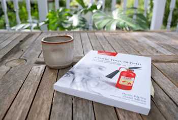 Fixing Your Scrum book on an outdoor table with a coffee mug