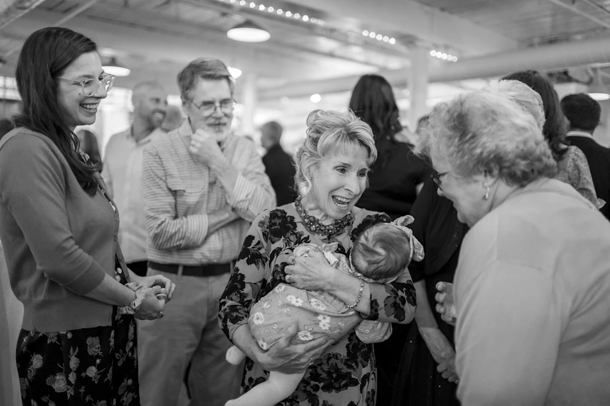 A grandmother showing a new baby to other family members in black and white.