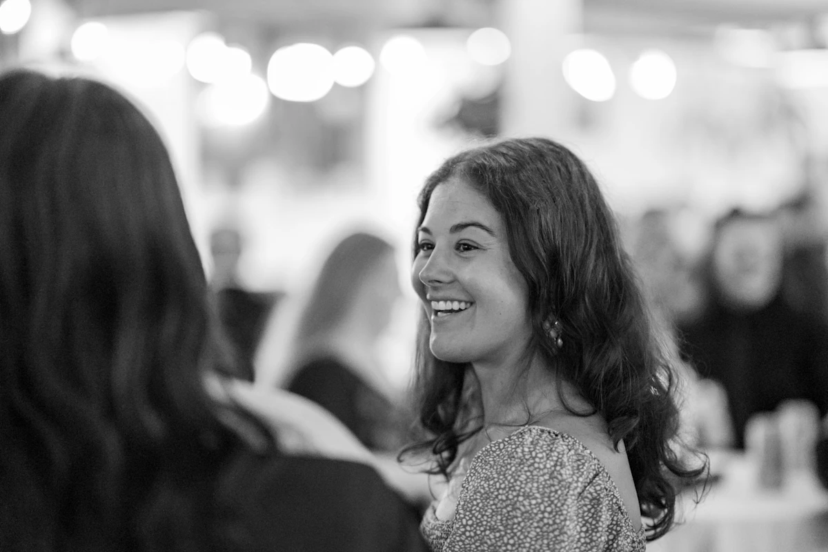 Woman smiling during conversation in black and white.