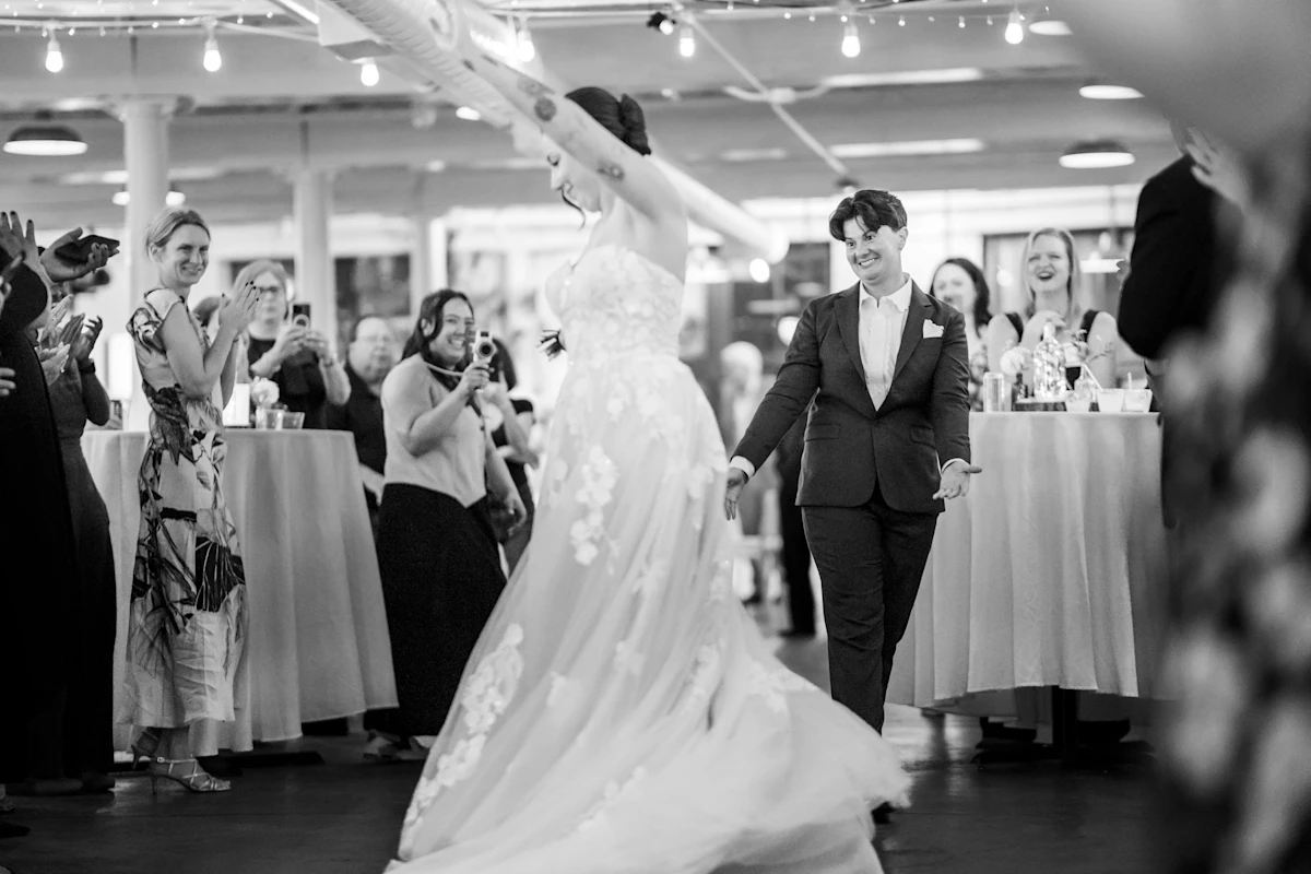 Bride smiling at bride as she dances in black and white