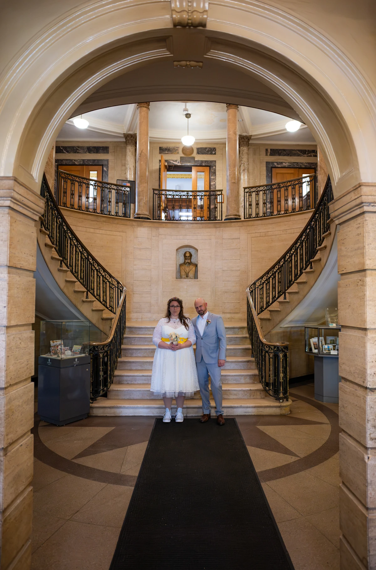Medford City Hall Elopement interior wide shot with bride and groom holding hands.