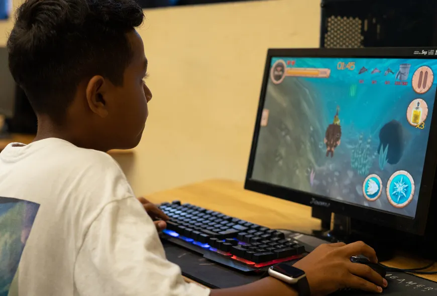 Niño jugando un videojuego en un computador.