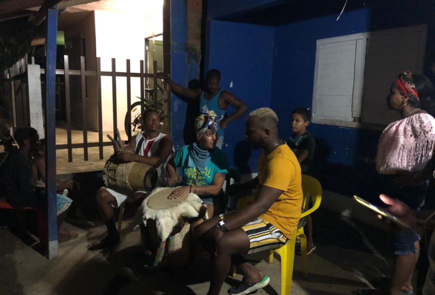 Un grupo de personas reunidas para escuchar los sonidos del tambor.