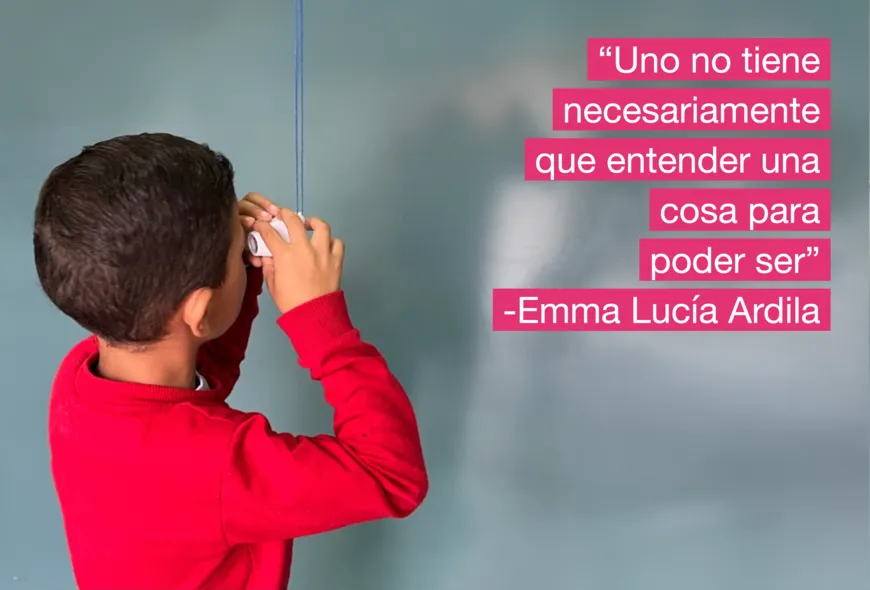Sobre la izquierda un niño sostiene un visor de foto antiguocolgado entre manos, observando la foto. Sobre la derecha hay un texto añadido que lee: "Uno no tiene necesariamente que entender una cosa para poder ser" -Emma Lucía Ardila