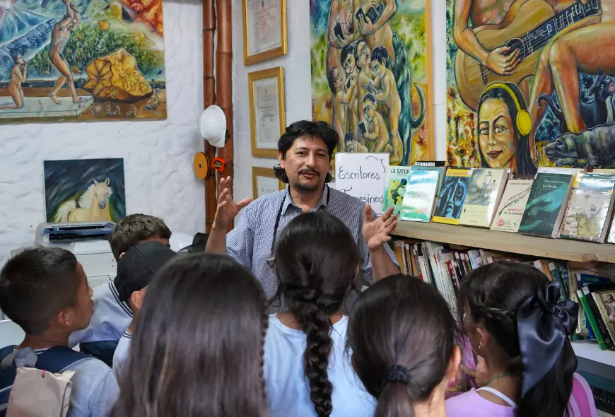 Foto de Gabriel enseñando al a librería al grupo de niños y niñas que la visitó.
