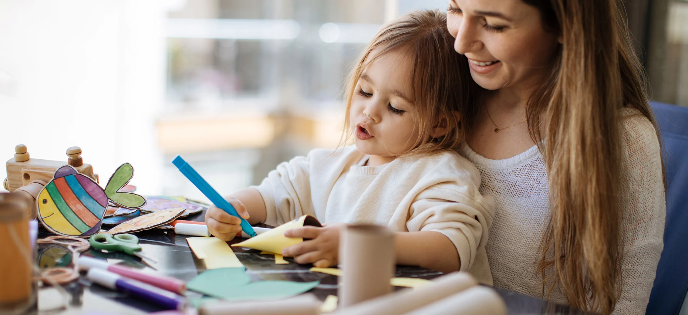 Una mujer haciendo trabajos manuales con su hija