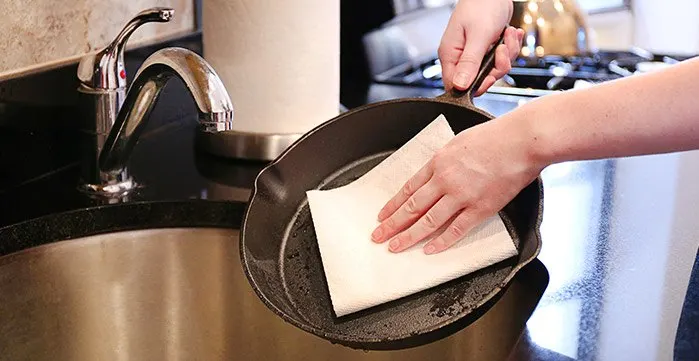 Cleaning Cast Iron by gently scrubbing with bounty paper towel