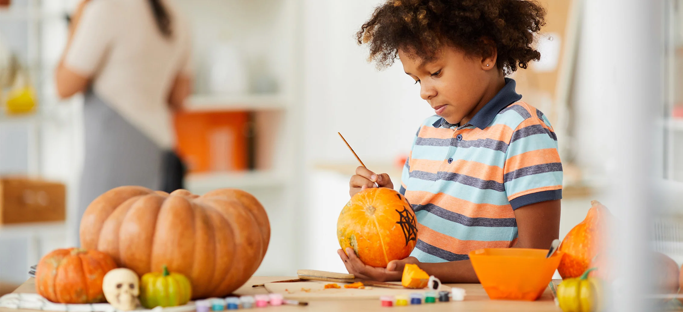 Young boy carving a pumpkin