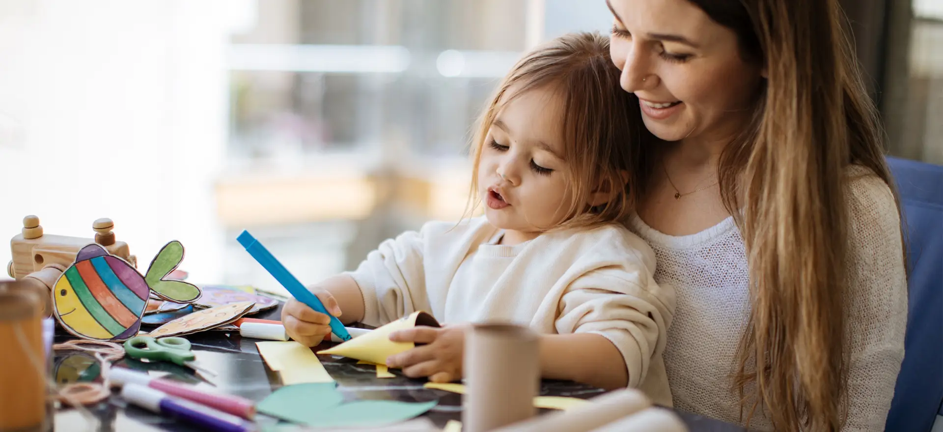 Una mujer haciendo trabajos manuales con su hija