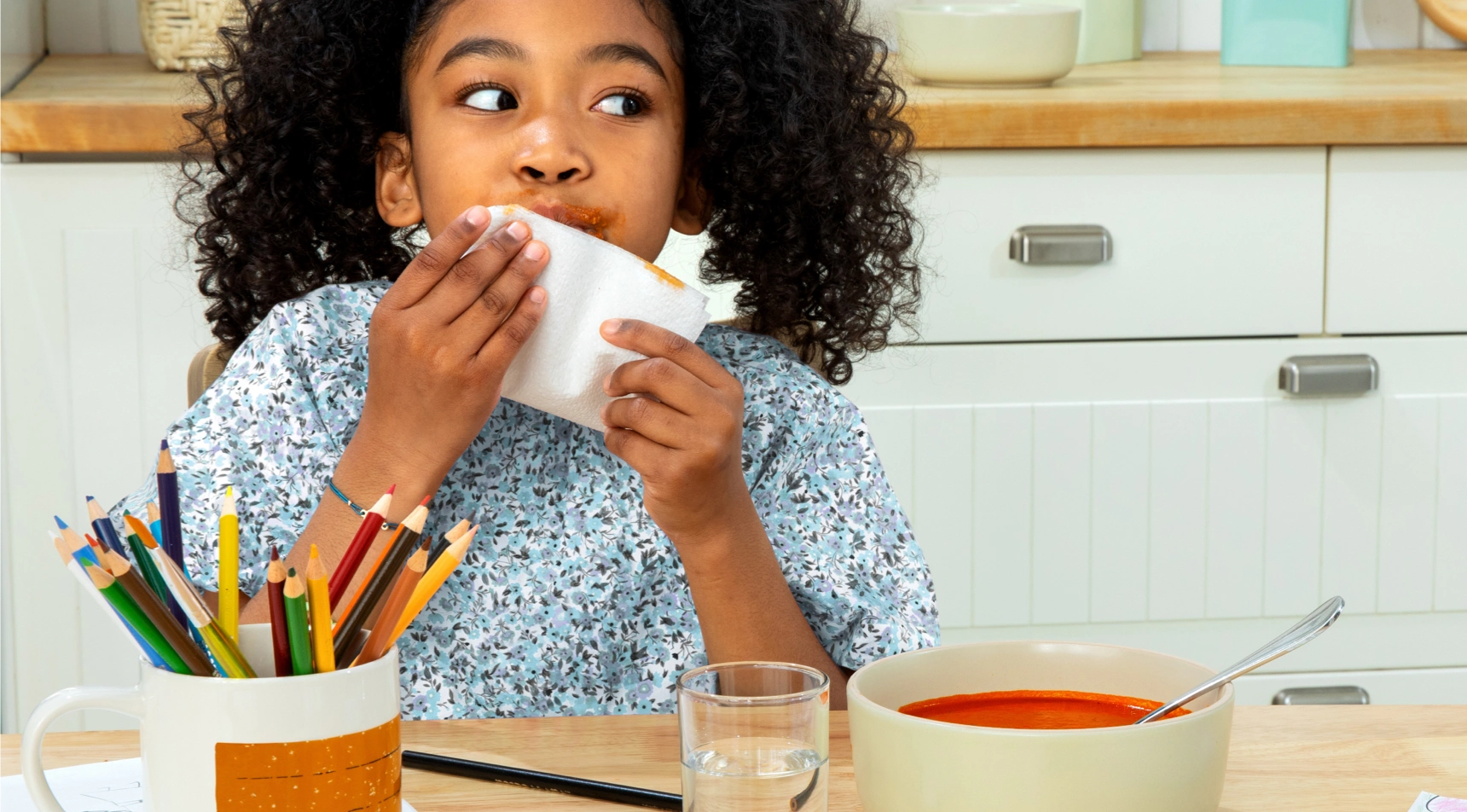 A young girl wiping her mouth with a Bounty paper napkin