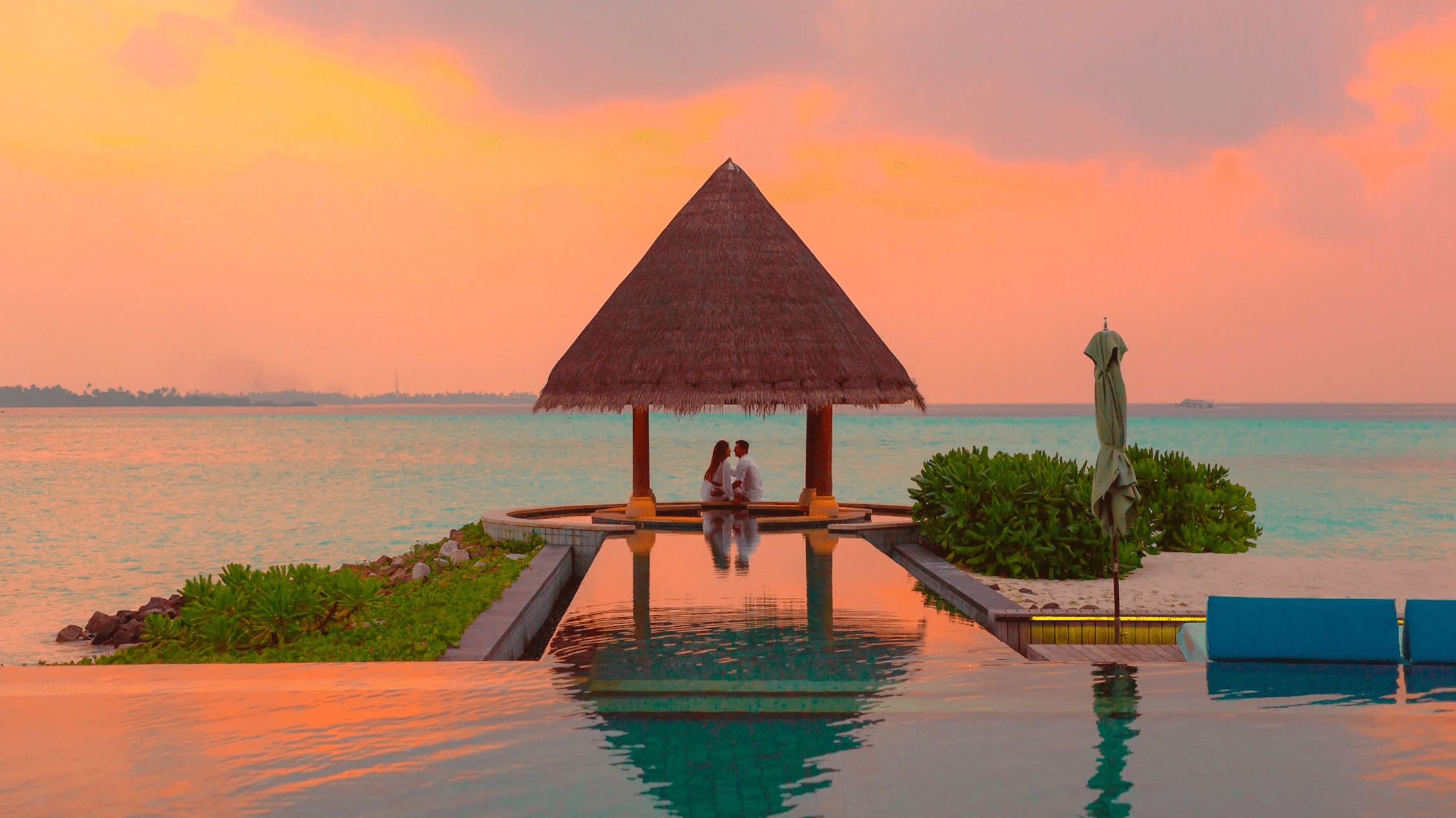 Couple during sunset near the pool on Maldives beach