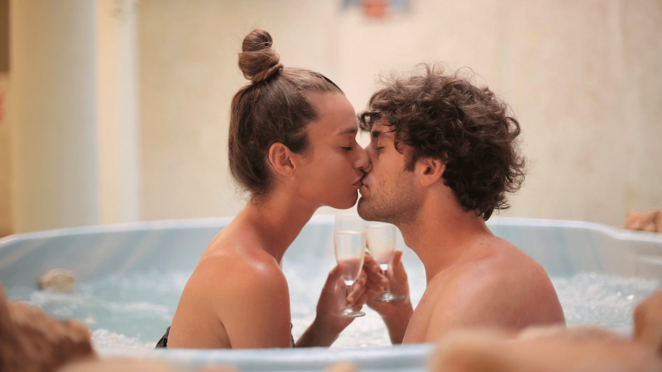 Couple drinking champagne and kissing in spa