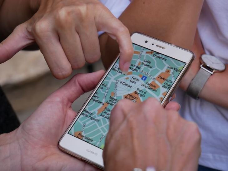 people pointing at a map on a phone