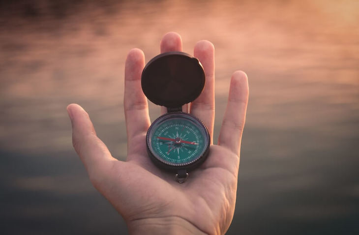 a hand holding a compass