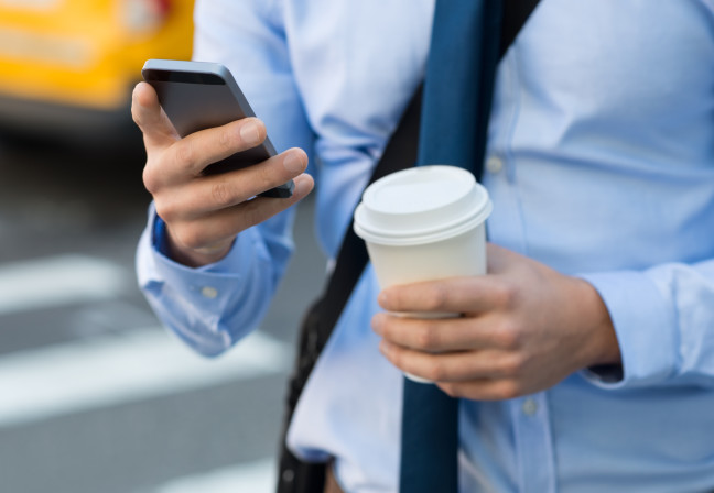 man with coffee cup on phone