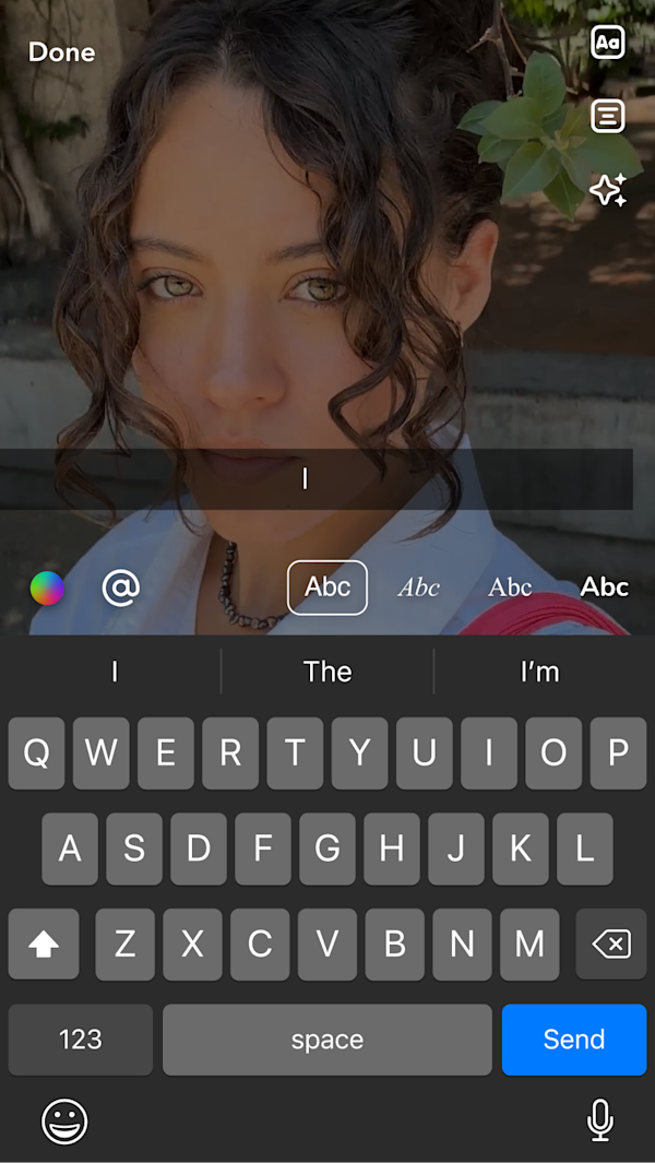 Mobile screen showing selfie with keyboard overlay for adding captions