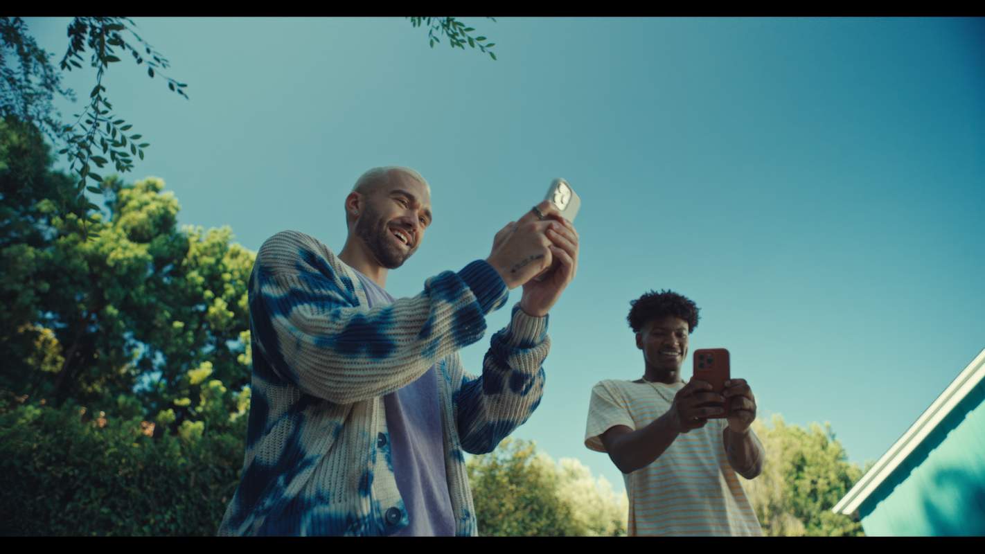 Two Snapchat Creators smiling while holding phones