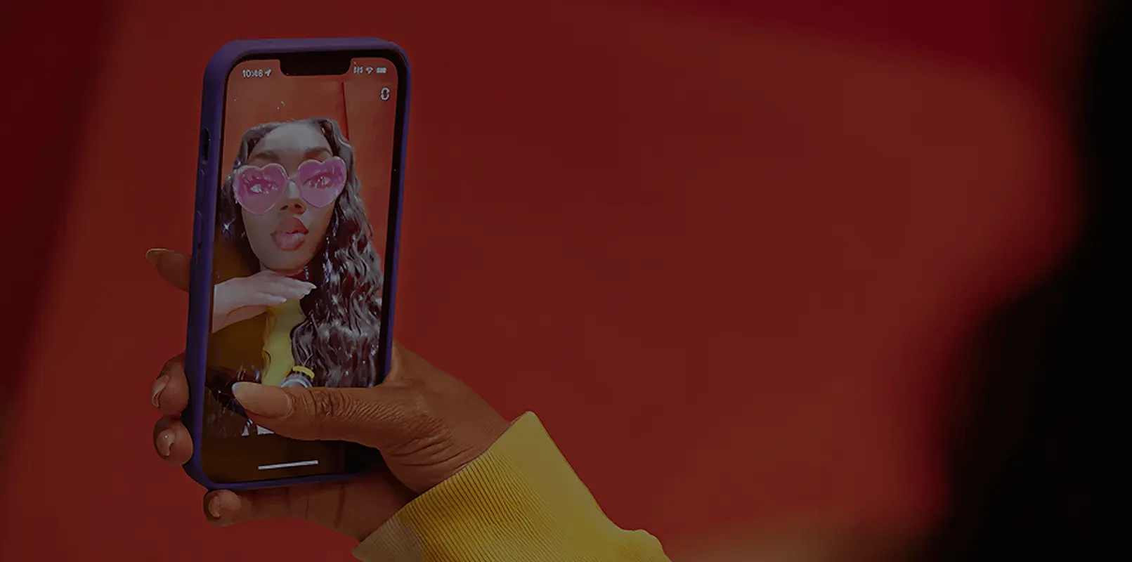 Phone screen showing a creator taking a mirror selfie in a red jacket