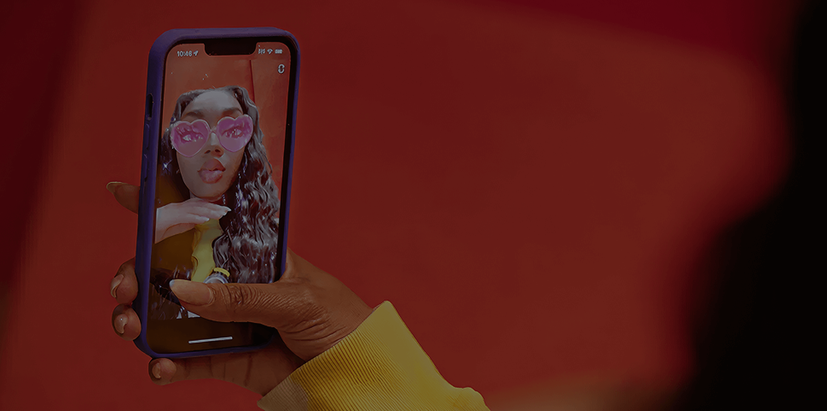Phone screen showing a creator taking a mirror selfie in a red jacket