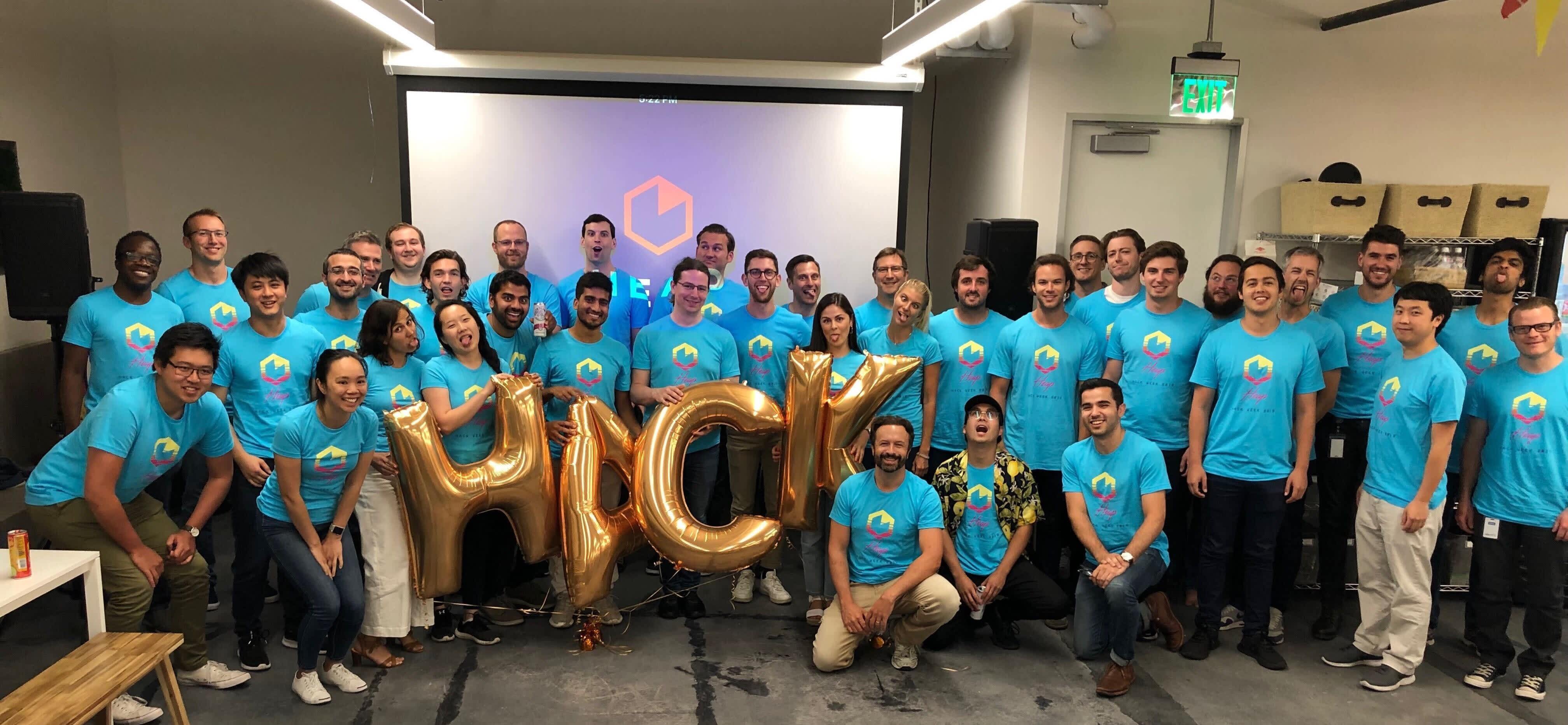Photo of the Heap Engineering Team holding balloons that spell out "Hack"
