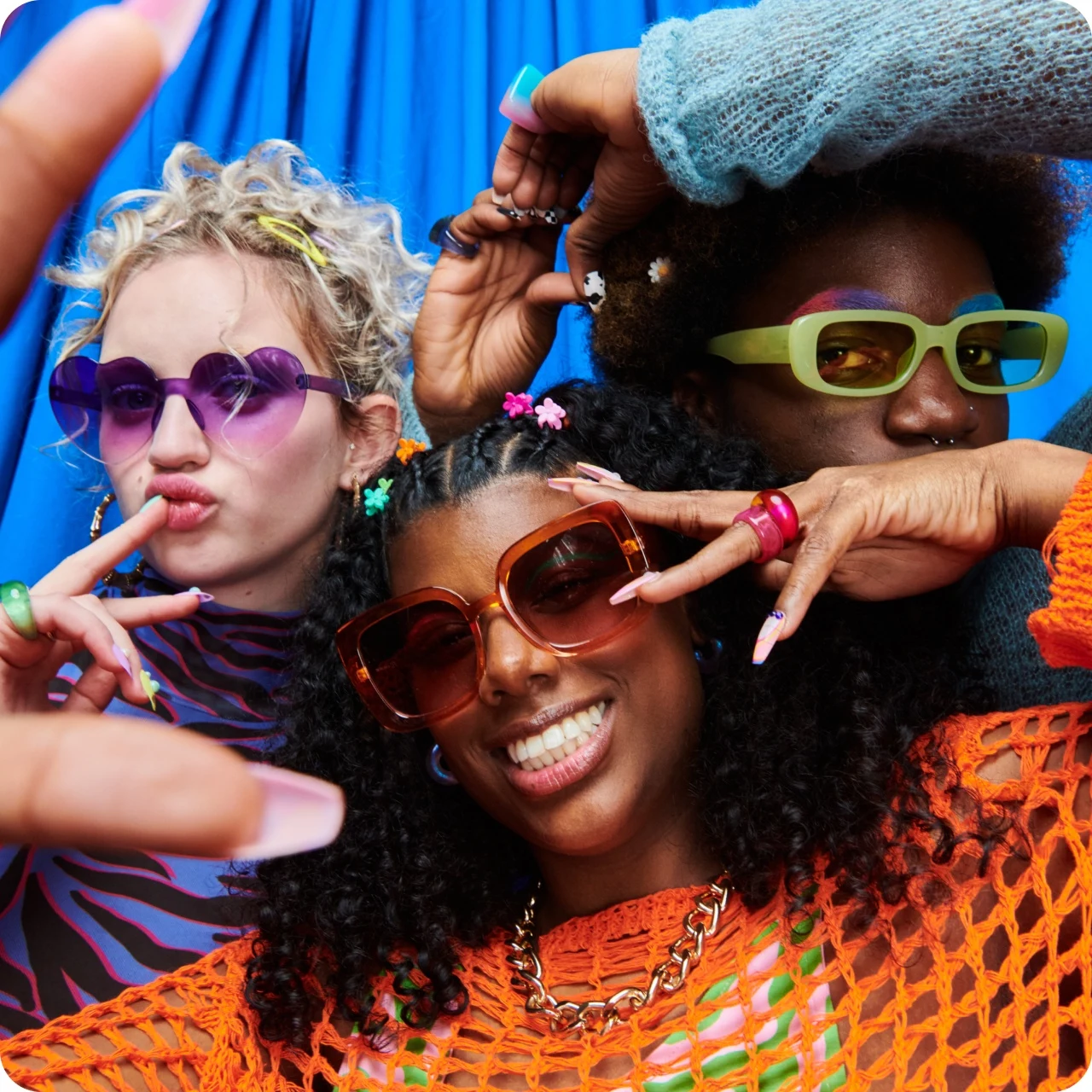Three young people wearing sunglasses posing for the camera