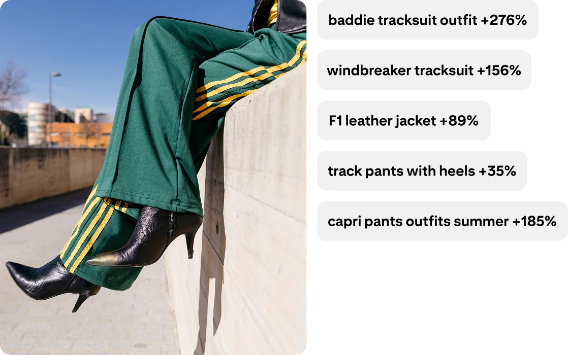 Legs wearing green track pants with yellow stripes on the side and pointed-toe heeled boots. Baddie tracksuit outfit +276%; windbreaker tracksuit +156%; F1 leather jacket +89%; track pants with heels +35%; capri pants outfits summer +185%.