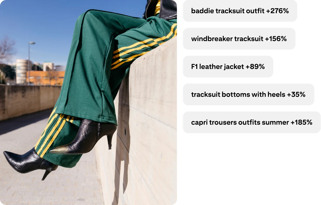 Legs wearing green tracksuit bottoms with yellow stripes on the side and pointed-toe heeled boots. Baddie tracksuit outfit +276%; windbreaker tracksuit +156%; F1 leather jacket +89%; tracksuit bottoms with heels +35%; capri trousers outfits summer +185%.