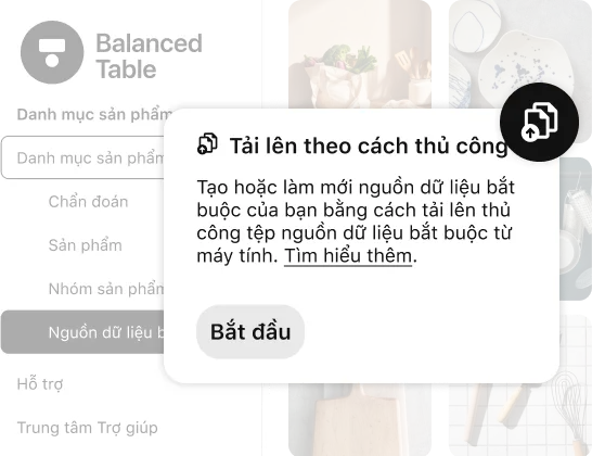 Giao diện danh mục sản phẩm của Pinterest có lớp phủ là cửa sổ pop-up để tải nội dung lên thủ công, hướng dẫn người dùng tải tệp lên để tạo hoặc làm mới nguồn dữ liệu bắt buộc, với nút CTA "Bắt đầu". Nền hiển thị hình ảnh mục sản phẩm và đồ dùng nhà bếp.