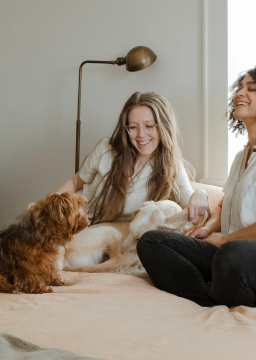 Duas mulheres dando risada com dois cachorros