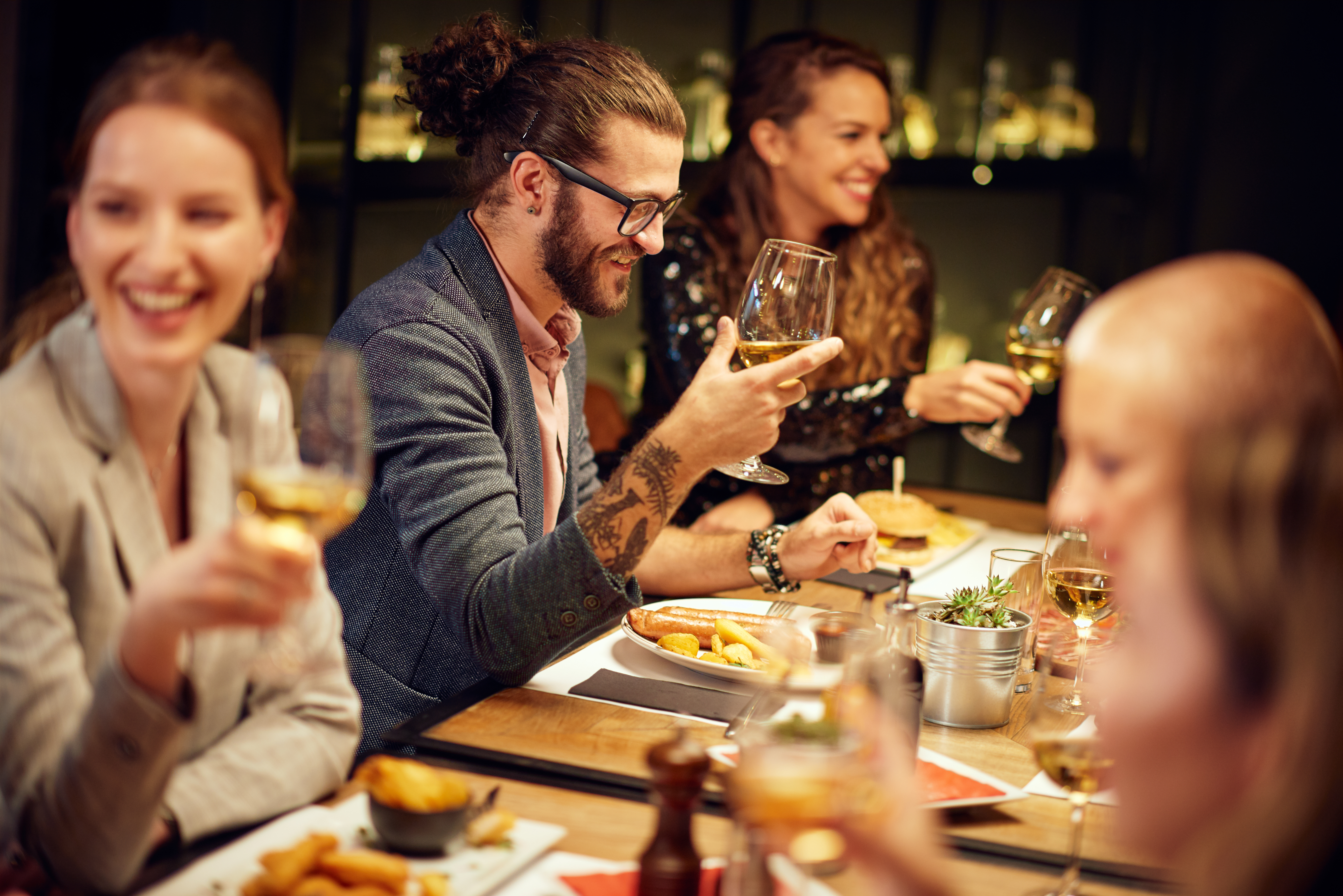 Tisch in einem edlen Restaurant mit Essen, Wein und Blumen.