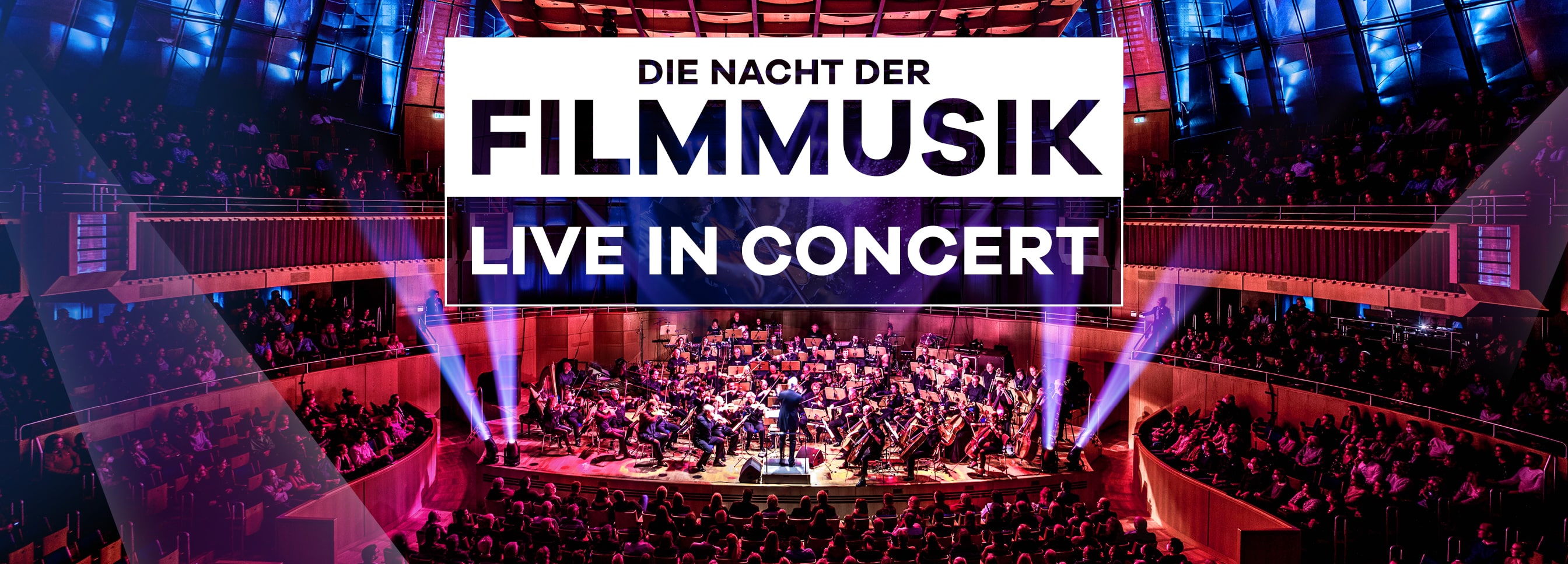 Großes Orchester spielt Filmmusik live auf einer Konzertbühne vor vollbesetztem Saal