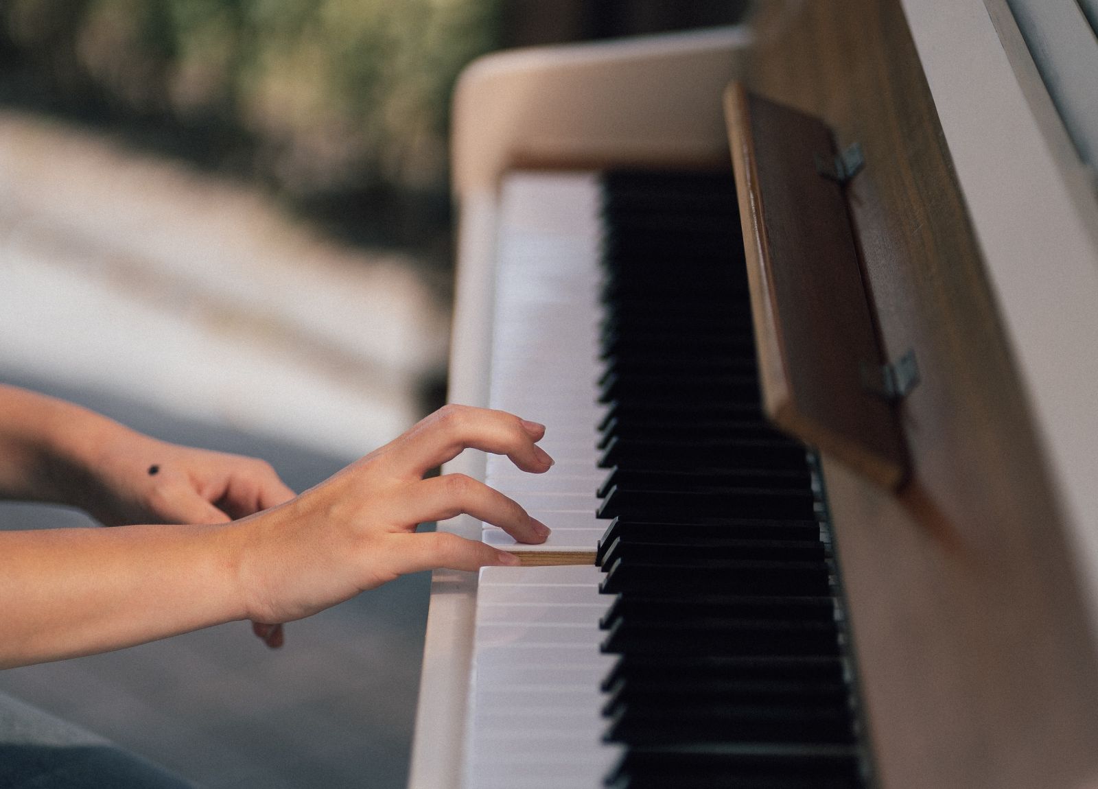 Hand, die eine Taste auf einem Klavier drückt