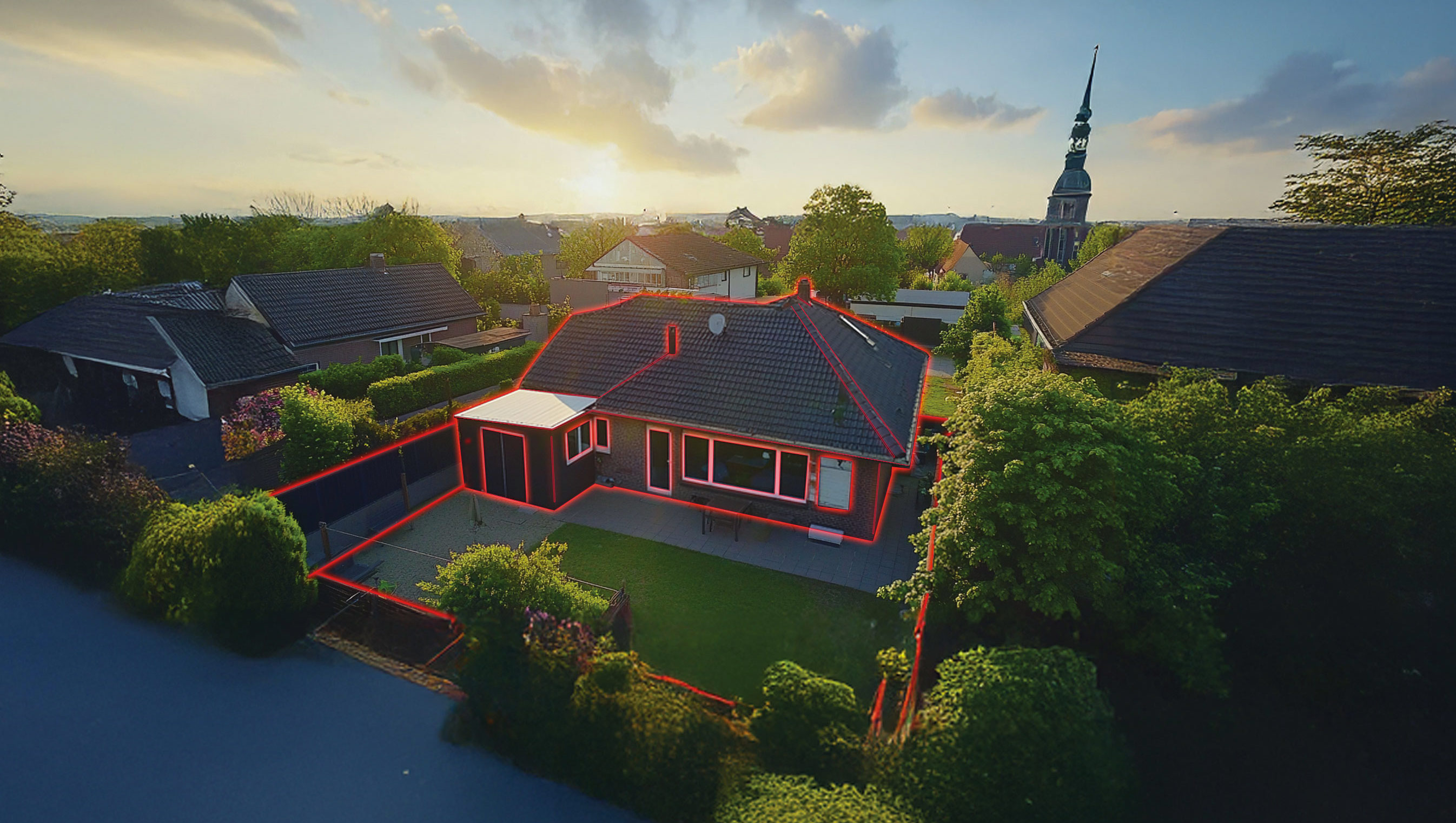 Einfamilienhaus mit Garten, von roter Linie umrandet, im Wohngebiet bei Sonnenuntergang