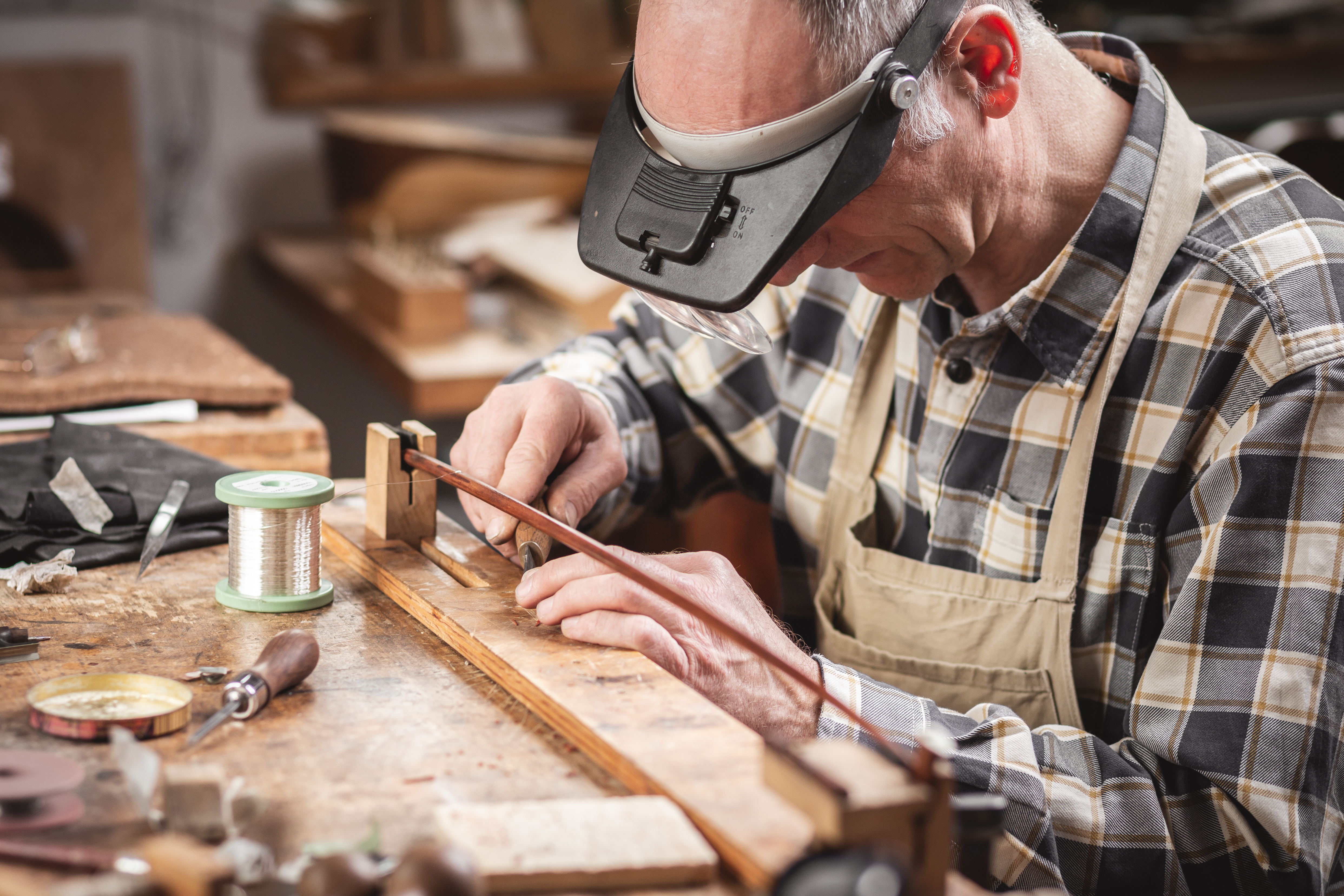 Instrumentenbauer fertigt einen Geigenbogen