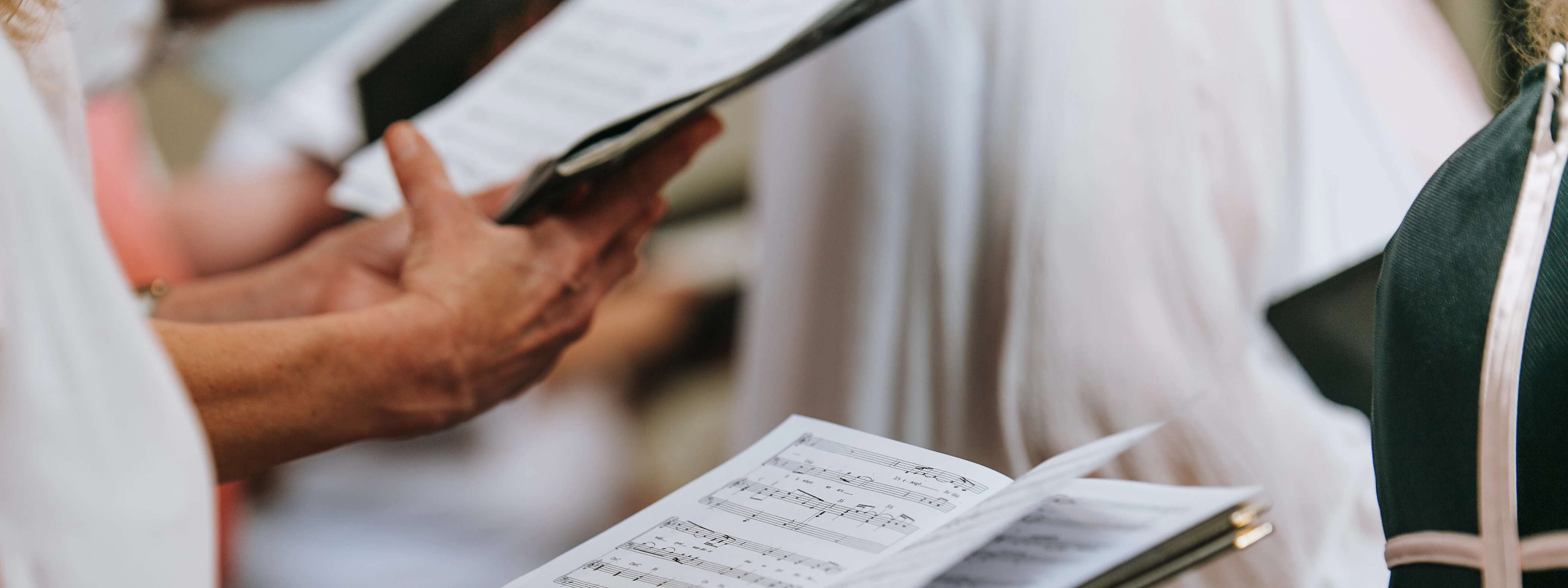 Hände, die ein Gesangsbuch halten